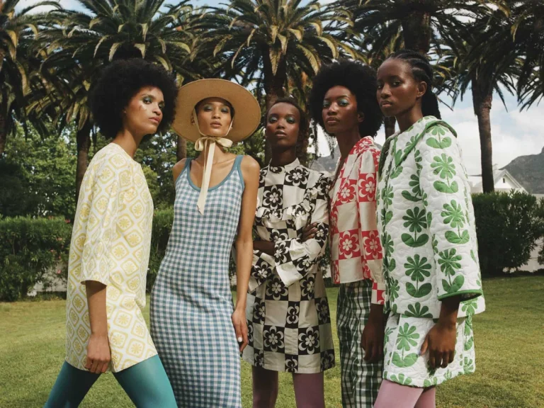 Realistic South African fashion scene featuring a stylish Black woman wearing contemporary locally inspired clothing in a modern urban setting.
