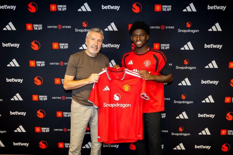 Carlos Baleba wearing a Manchester United shirt after completing his transfer