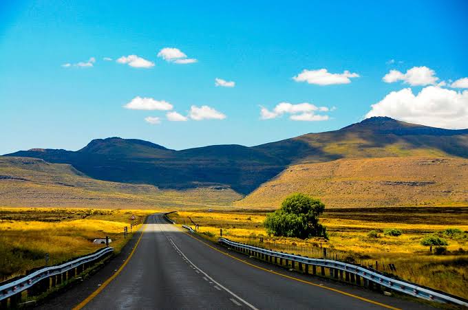 Scenic South African weekend getaway with dramatic mountains, lush countryside and a peaceful road stretching into the landscape.