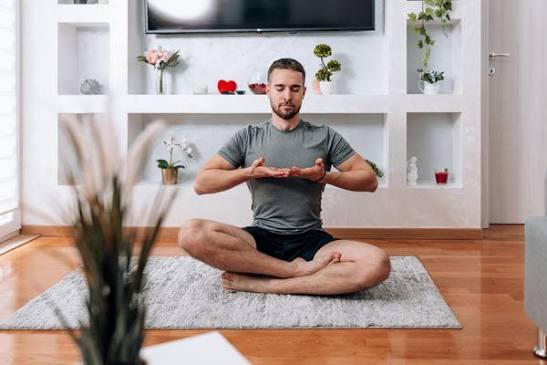 Realistic South African professional taking a mindful break outdoors, using breathing and relaxation techniques to manage everyday stress.